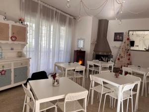 un comedor con mesas blancas y un árbol de Navidad en Comeacasatua 2.0, en Bari