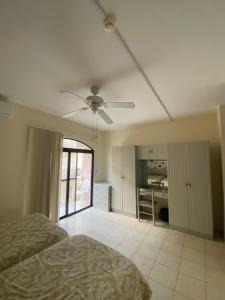1 dormitorio con 1 cama y ventilador de techo en Seafront akwador en Il-Ħamrija