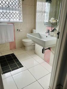 a white bathroom with a sink and a toilet at musgrave manors villa in Durban
