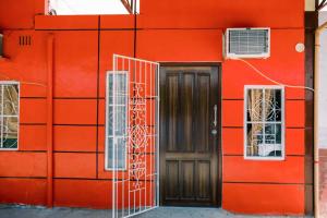 een rood gebouw met een deur en twee ramen bij Arka's Elegant Condos in Zamboanga