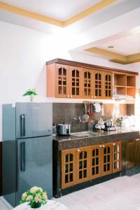een keuken met houten kasten en een roestvrijstalen koelkast bij Arka's Elegant Condos in Zamboanga
