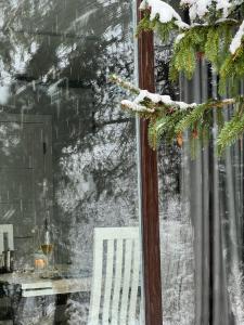 einem verschneiten Fenster mit einem weißen Stuhl und einem Tisch in der Unterkunft Sonna in Podzakharychi