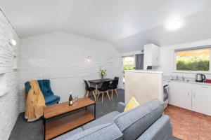 a living room and kitchen with a couch and a table at Aarangi Motel in Auckland