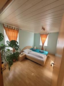 ein Schlafzimmer mit einem Bett und einer Topfpflanze in der Unterkunft Casa Carolina Rumänisches Restaurant & Pension in Stedtfeld
