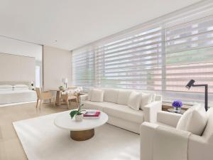 a living room with a white couch and a table at The Singapore EDITION in Singapore