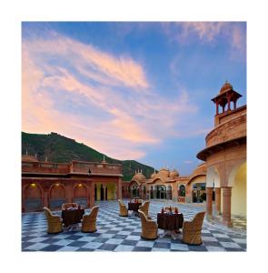 a courtyard with tables and chairs in a building at Patan Mahal in Pātan