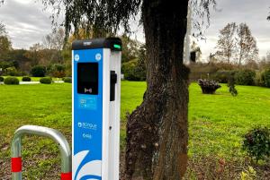 un teléfono público azul y blanco junto a un árbol en Hotel Capolago, en Varese