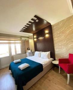 a bedroom with a large bed and a red chair at Koc Hotel in Karasu