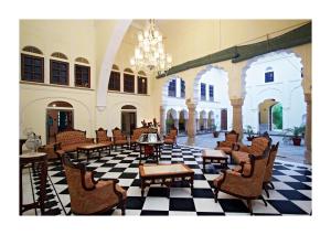 a lobby with chairs and a table and a chandelier at Patan Mahal in Pātan