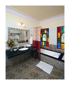 a bathroom with a sink and a mirror at Patan Mahal in Pātan