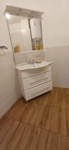 W łazience znajduje się umywalka i lustro. w obiekcie апартамент Римската стена w mieście Chisaria