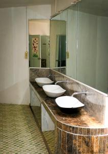a bathroom with three sinks and a large mirror at Mandalika Queen Hostel in Kuta Lombok