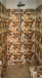 a stone wall with a chandelier in a bathroom at Mandalika Queen Hostel in Kuta Lombok