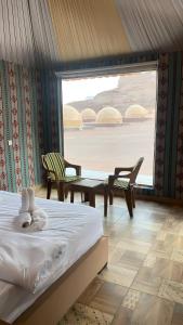 a bedroom with a bed and a table and chairs at Yellow Star Camp Wadi Rum in Wadi Rum