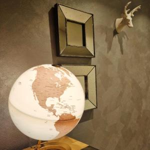 Un globe sur une cage à côté d'un mur avec des cadres d'images dans l'établissement MH Olen Boutique Hotel, à Alagna Valsesia