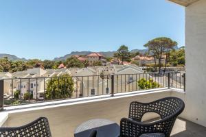 een balkon met stoelen en uitzicht op de gebouwen bij Luxury Escape at Alphen Glen Constantia in Kaapstad