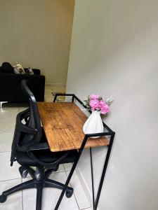 een tafel met een vaas met bloemen erop bij Neat and cozy apartment in central Rosebank with unlimited Wi-Fi and backup power in Johannesburg