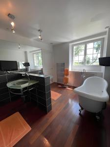 a bathroom with a tub and a desk and a sink at Domaine de la Belvaudière - luxueux - 24H du Mans - 20p - Rêve au Mans in Saint Pavace