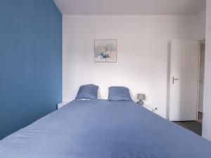 a blue bedroom with a large bed with blue sheets at Aux Lilas - Hyper Centre - Wifi - 5 personnes - Rêve au Mans in Le Mans
