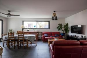 a living room with a red couch and a table at Cassiopée - Jacuzzi - Unique - 8p - Rêve au Mans in La Bazoge