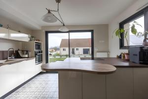 a kitchen with white cabinets and a large window at Cassiopée - Jacuzzi - Unique - 8p - Rêve au Mans in La Bazoge