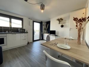 een keuken met een houten tafel en witte kasten bij Le Ruby - centre - wifi 2p - Rêve au Mans in Le Mans