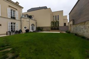 a large house with a green lawn in the yard at Le Serengeti - Piscine - 7pers - Circuit Bugatti - Rêve au Mans in Le Mans