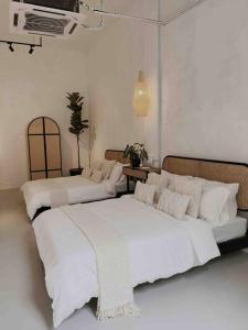 two beds in a room with white walls at Heritage Boutique Home in George Town