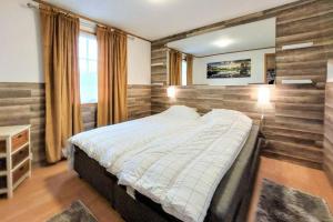 ein Schlafzimmer mit einem Bett und einem großen Fenster in der Unterkunft Minnebo stuga in Hässleholm