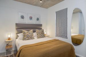 een slaapkamer met een groot bed en een spiegel bij Luxury Escape at Alphen Glen Constantia in Kaapstad