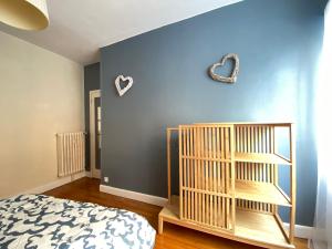 - une chambre dotée d'un mur bleu avec un lit et une étagère dans l'établissement Grand T2 très fonctionnel à deux pas du centre - Morel Ladeuil, à Clermont-Ferrand
