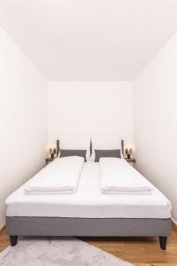 Duas camas num quarto com paredes brancas em Apartment - Lärchenhof em Mauterndorf