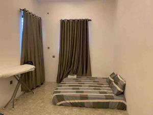 ein Schlafzimmer mit einem Bett in einem Zimmer mit Vorhängen in der Unterkunft 4 Bedroom Apartment Available in Uyo