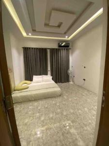 ein Schlafzimmer mit einem Bett in der Mitte eines Zimmers in der Unterkunft 4 Bedroom Apartment Available in Uyo