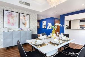 a dining room with a white table and chairs at Dream Inn Apartments - Al Sahab in Dubai