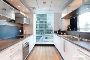 a kitchen with white cabinets and a large window at Dream Inn Apartments - Al Sahab in Dubai