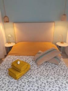 a bed with two pillows on it with two tables at Arlette la petite maison Arlésienne in Arles