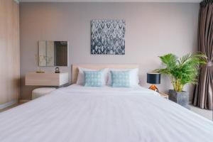 チェンマイにあるModern Condo in Nimman (F807) by Pimolplaceの大きな白いベッドと青い枕のある寝室