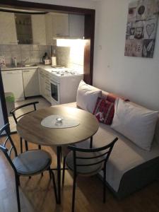 un soggiorno con divano e tavolo con sedie di Apartman Ris Gorski Kotar Crni Lug a Delnice