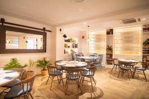 a restaurant with tables and chairs and a mirror at Gran Hotel Flamingo-Adults Only older 18 years old in Lloret de Mar