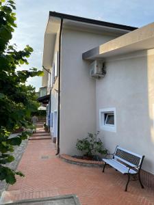 a bench sitting on a brick walkway next to a building at Caterina e l'Indaco in Sarzana