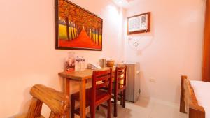einen Esstisch mit Stühlen und ein Gemälde an der Wand in der Unterkunft RedDoorz Plus @ Jollydays Hotel Nueva Ecija in San Jose