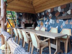 a table and chairs in a room with a stone wall at Villa Premium Qusar in Qusar