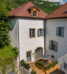 Elle offre une vue aérienne sur une maison blanche dotée d'une terrasse. dans l'établissement Le Chicissime, coeur du village, LLA Selections by Location lac Annecy, à Talloires