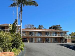 a building with a palm tree in front of it at Ocean View Motor Inn Merimbula in Merimbula