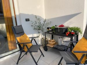 a balcony with two chairs and a table with plants at Valkane Beach Apartments in Pula