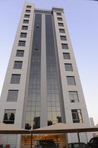 a tall white building with a lot of windows at AlSharq Residence in Kuwait