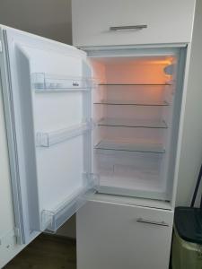 an empty refrigerator with its door open in a kitchen at FeWo Robin in Bad Harzburg