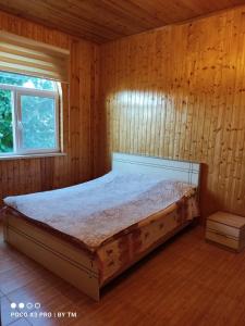a bedroom with a bed in a wooden wall at Villa Premium Qusar in Qusar