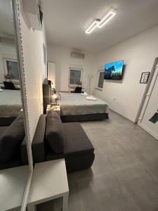a bedroom with two beds and a couch and a mirror at Venite Rooms in Velika
